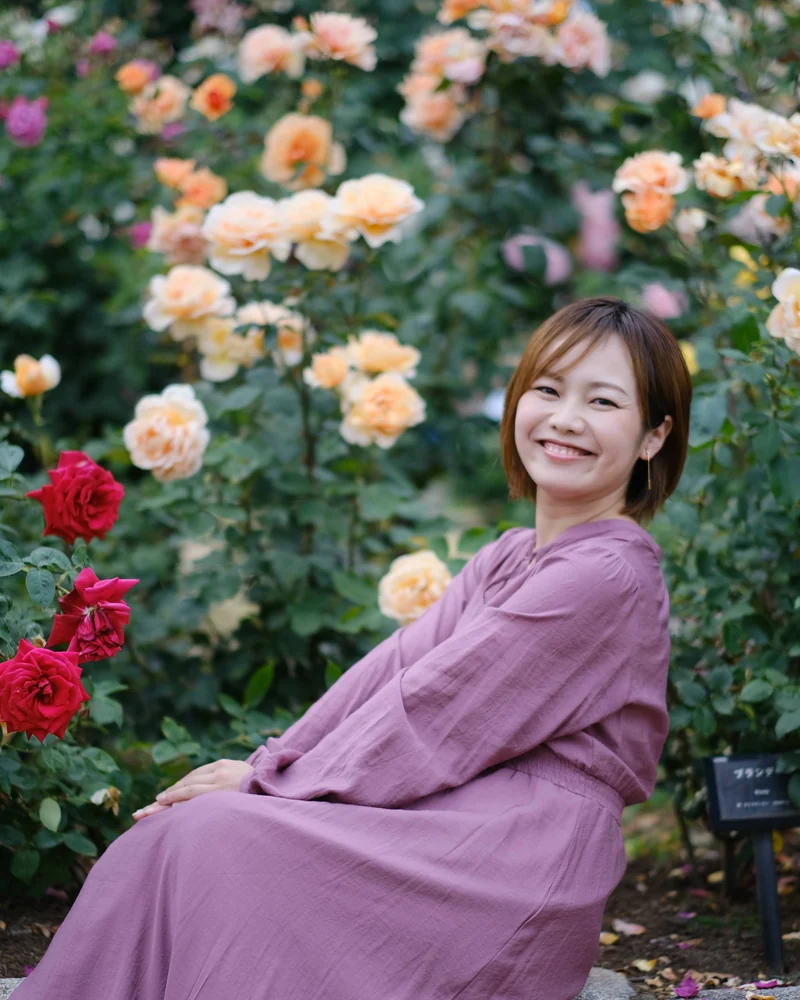薔薇の咲く庭でカメラに微笑みかける平野綾菜