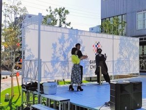 別府マルシェのステージ上で竹細工のお店の竹とんぼを飛ばす平野綾菜