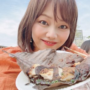 別府マルシェ内店舗の料理を手に平野綾菜