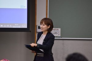 司会をする黒っぽい服を来た女性