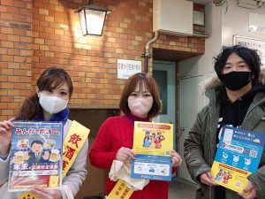 左と真ん中に女性、右の男性。その手に飲酒運転撲滅と運転代行のチラシ