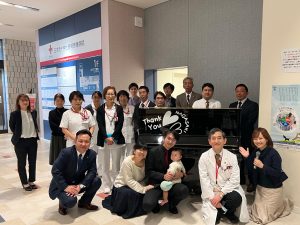 ピアノの前、みんなで記念写真