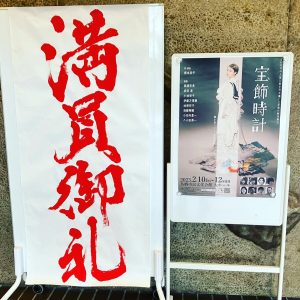 舞台「宝飾時計」のエントランスに表示されてる「満員御礼」の看板と舞台の看板