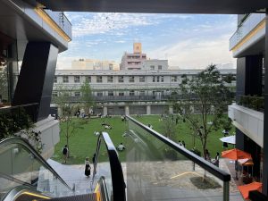 ビルの踊り場。芝生広場に多くの人がくつろぐ様子