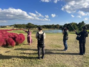 池のほとり（海の中道海浜公園）でのロケ中の女性
