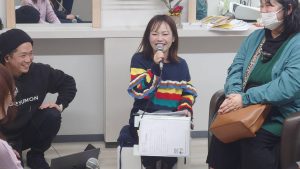 美容室内、ラジオ番組の収録でマイクをもつ女性MC