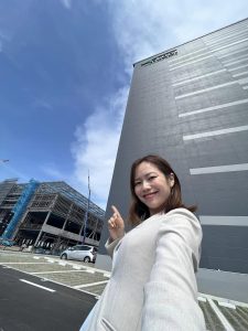 高いたてものをバックに女性が自撮り