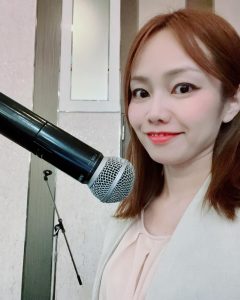 マイクの前に立つ女性