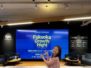 イベント会場でモニターの前に女性が振り返り姿