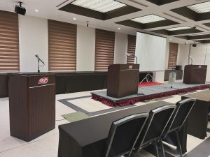 式典会場に司会台３段、その前にテーブルと椅子が並ぶ