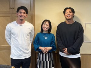 男性２人の間に女性の記念写真