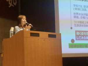 女性が司会台で抗議中