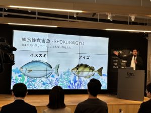 プロジェクターに魚の絵を映し説明する登壇者