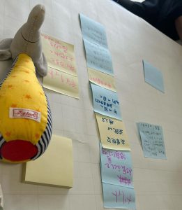 ボード上にメモ書きされた付箋紙が多数、その上にぬいぐるみ