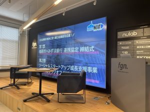 壇上 大型モニターとテーブル２つ椅子２つ