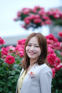 たくさんのバラをバックに女性のバストアップ画像