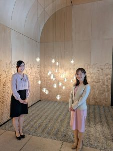 アーチ状の屋根から吊るされたライトの下に女性が２人
