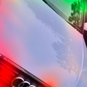 車のボンネットに綺麗なグラデーションの光が反射