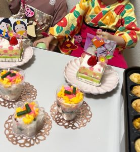 こども２人の前にケーキとバラ寿司