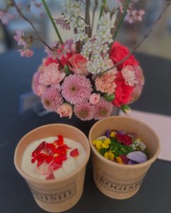 カップに入ったデザートと活けられた花