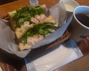 お肉の入ったサンドイッチとコーヒー