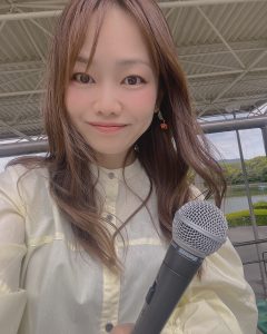 女性がマイク片手に持つ