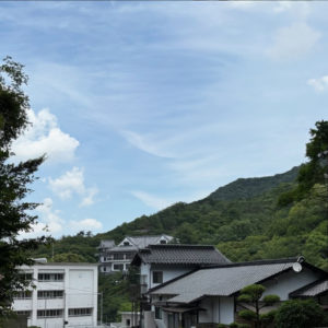 山間の家屋と青空