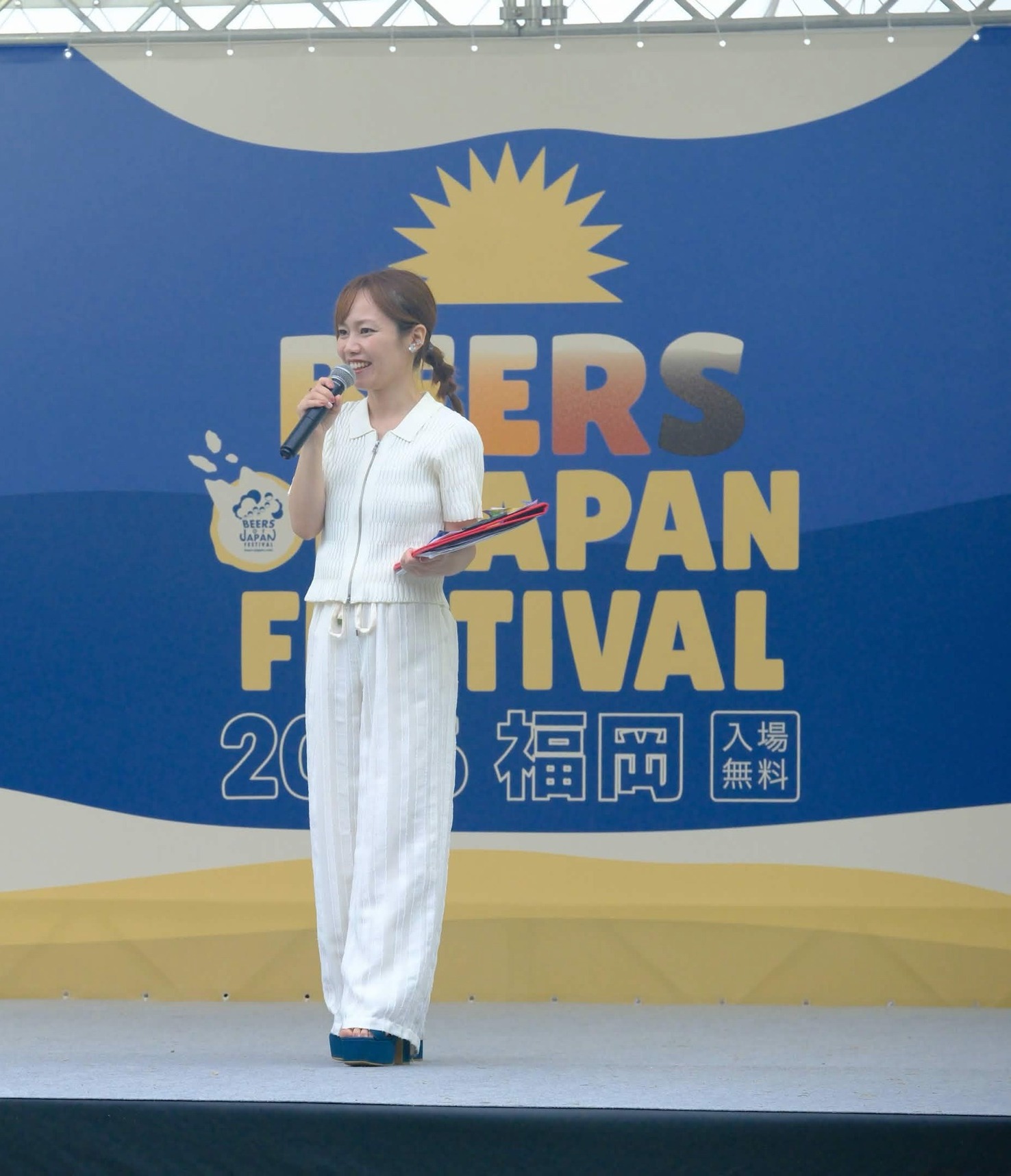 ステージでマイクを持ち笑顔で話す平野綾菜