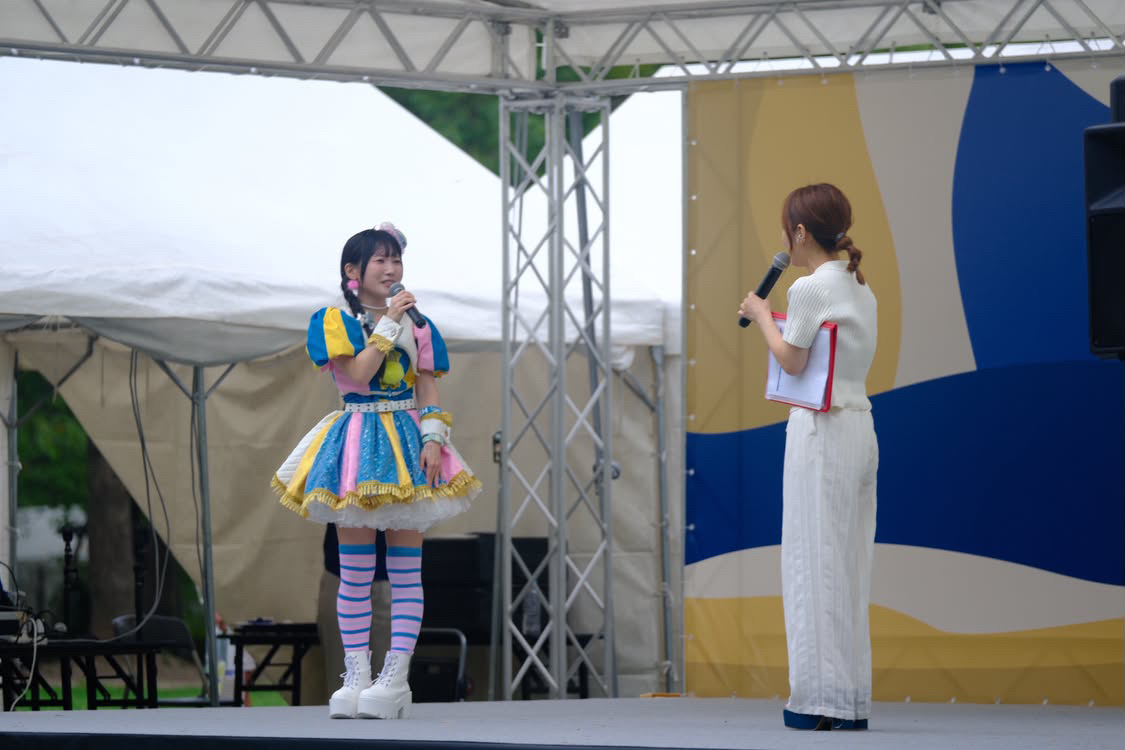 ステージでゲストに進行のマイクを向ける平野綾菜