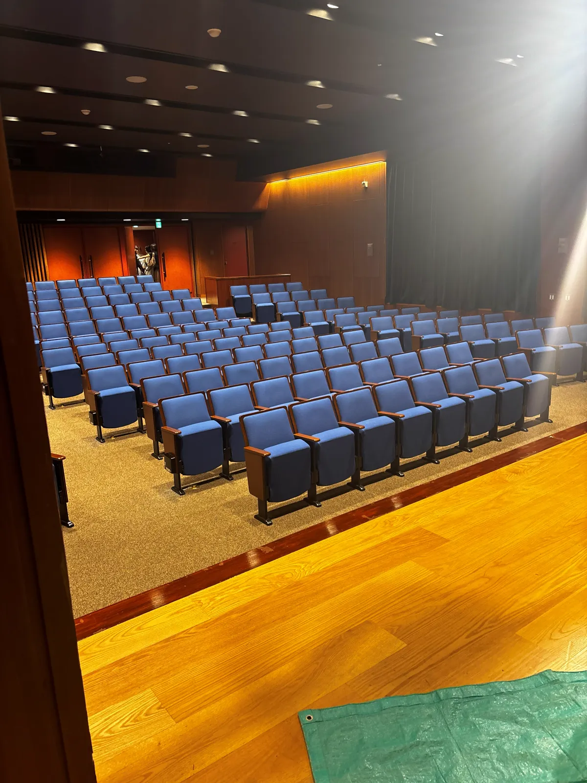 開演前の福岡市美術館のホール。青い客席が舞台に向かって並んでいる