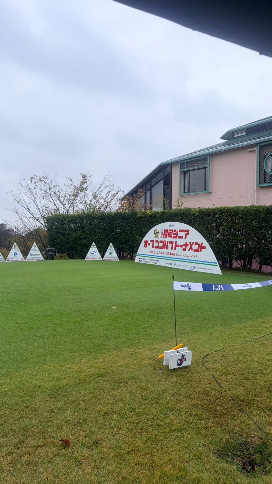 今年の大会。「福岡シニアオープンゴルフトーナメント」の大会看板と、グリーン脇に並ぶ協賛の看板
